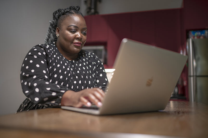 Photo d'une femme assise à un bureau et travaillant sur son ordinateur portatif.