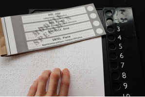 An elector reads a ballot written in braille